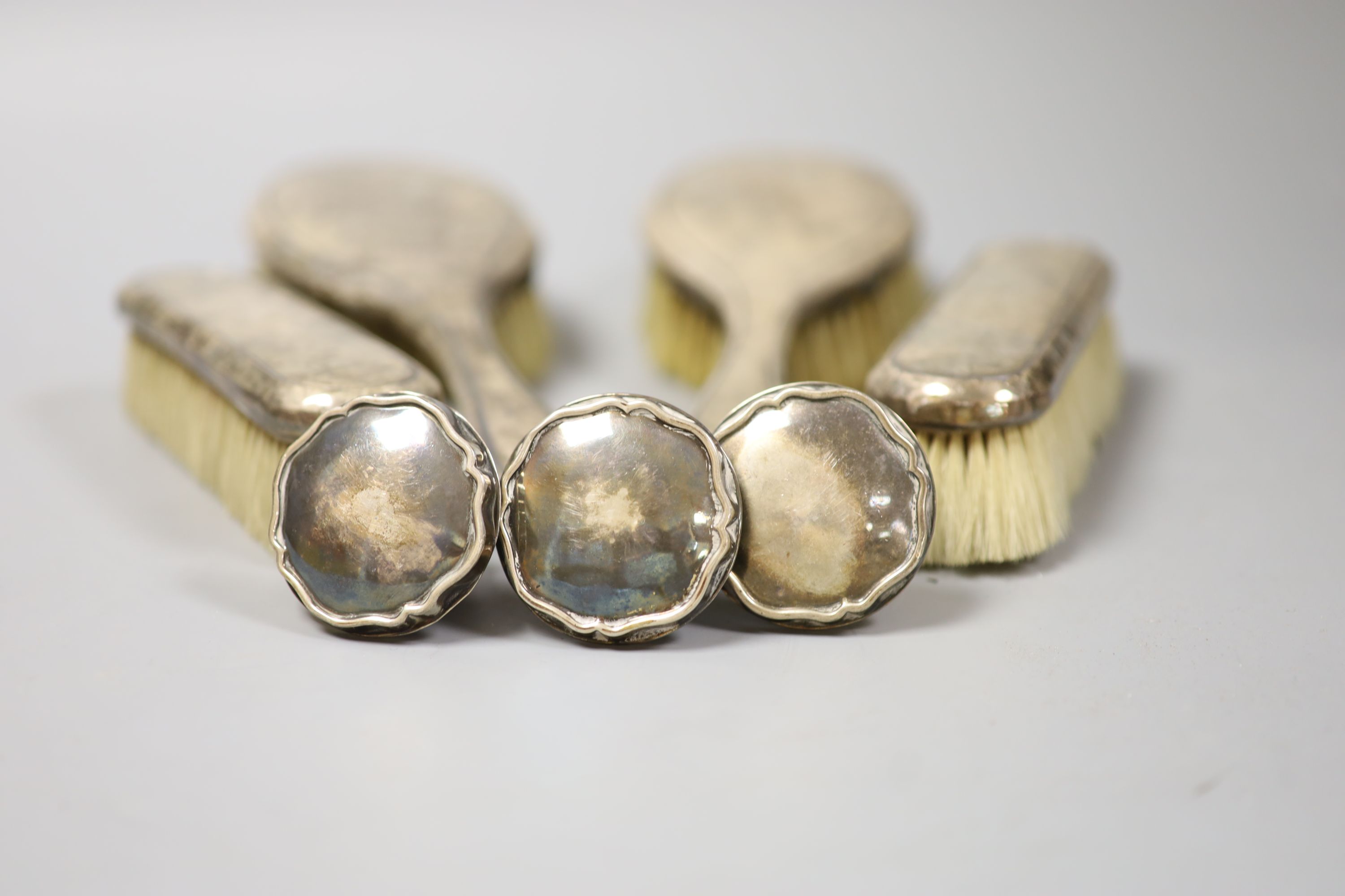 Four silver mounted brushes and three 830s mounted stoppers.